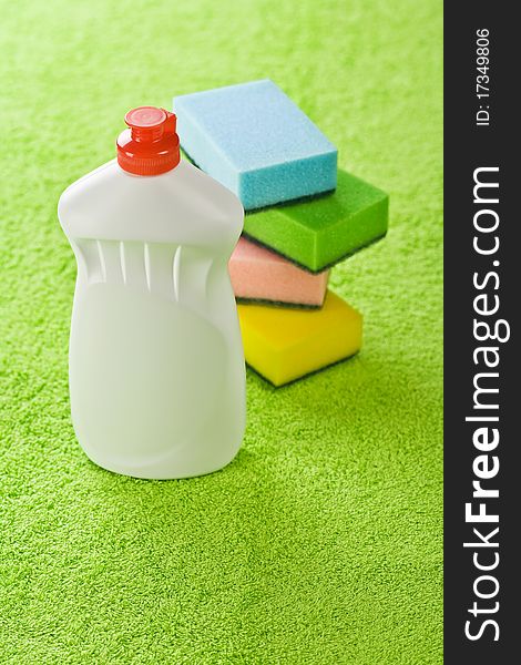 Bottle and sponges on a background of a green towel. Bottle and sponges on a background of a green towel