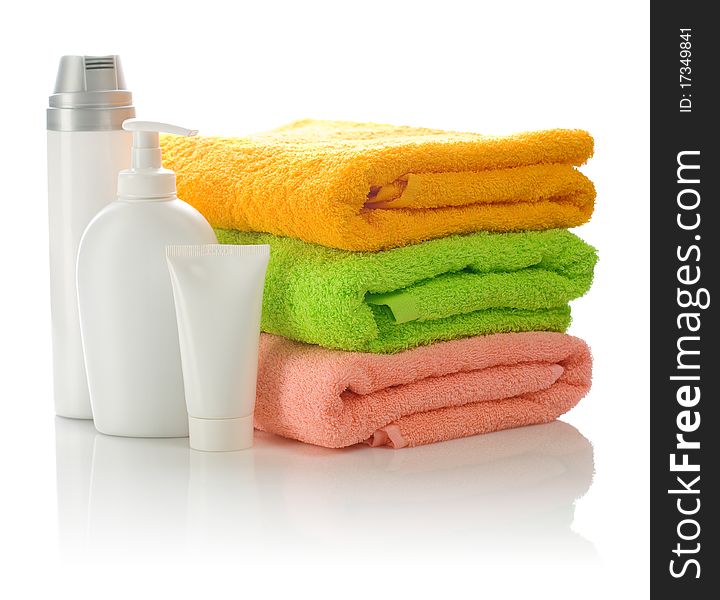 Bottles and tube with towels isolated on white background