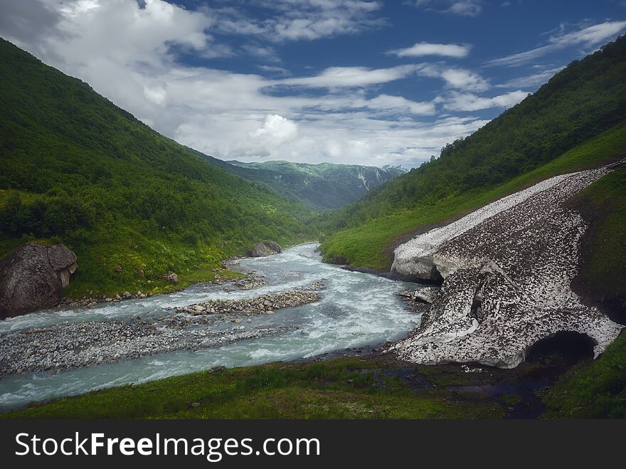 Fast mountain river flows near old glacier after rain. Georgia. Caucasus Mountains. Summer season