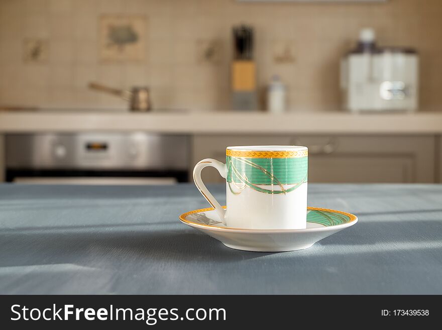 Coffee or teacup on a wooden surface of dark gray color on a blurred background of the kitchen