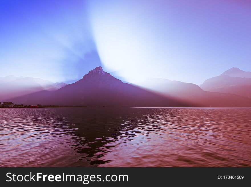 Fantastic landscape. Lights and shadows in the mountains and on the water of the lake. Fantastic landscape. Lights and shadows in the mountains and on the water of the lake