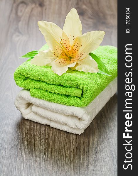 Flower on two green and white towels on wooden background. Flower on two green and white towels on wooden background