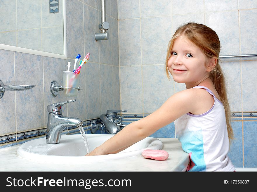 Little girl washing in bathroom