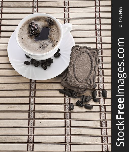 Composition of coffee mug with beans and cookie