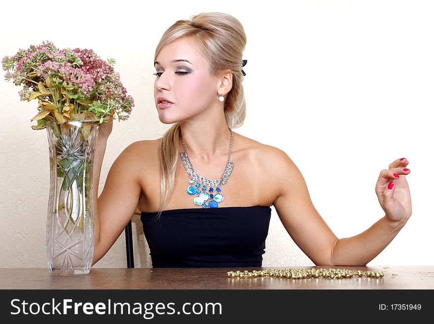 Woman looking a autumn flowers against yellow wall at table