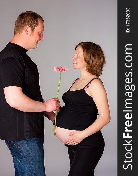 Pregnant woman with flower and her husband. Pregnant woman with flower and her husband