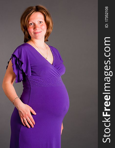 Beautiful pregnant woman staing on grey background