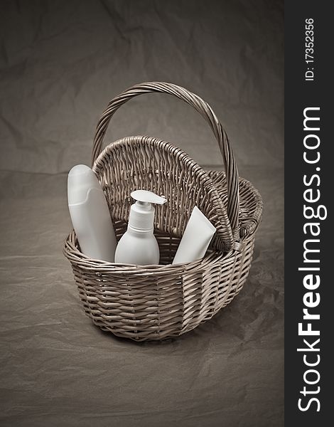 Basket with bottles and tube on paper background