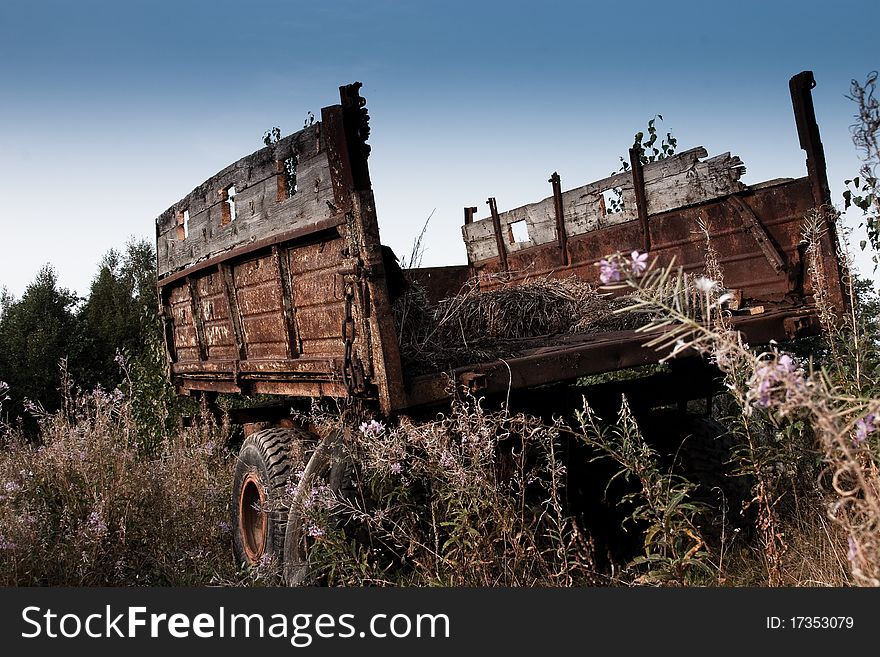 Abandoned old tractor trailer, in the field of overgrown grasses