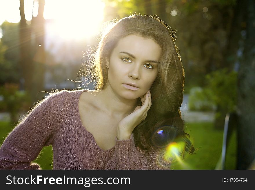 A portrait of beautiful brunett girl is in the sun forest