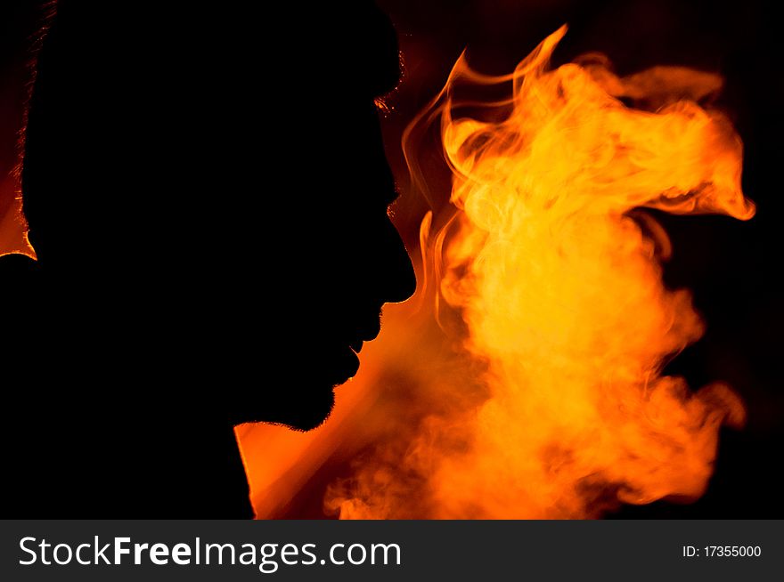 Silhouette of a man's face just next to the illuminated smoke that he had exhaled. Portraying power and dynamism. Silhouette of a man's face just next to the illuminated smoke that he had exhaled. Portraying power and dynamism.