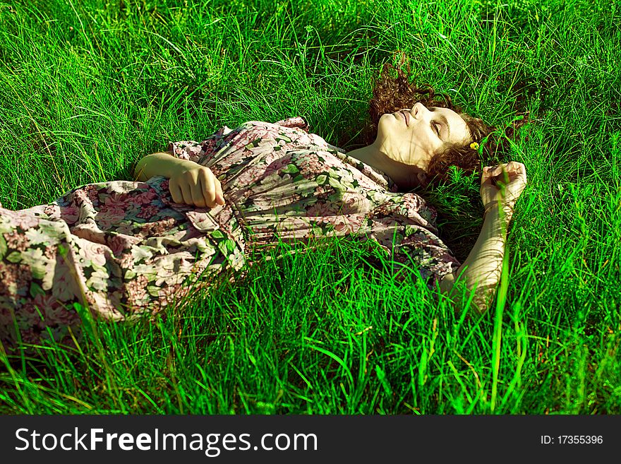 A beautiful girl lies in a green grass