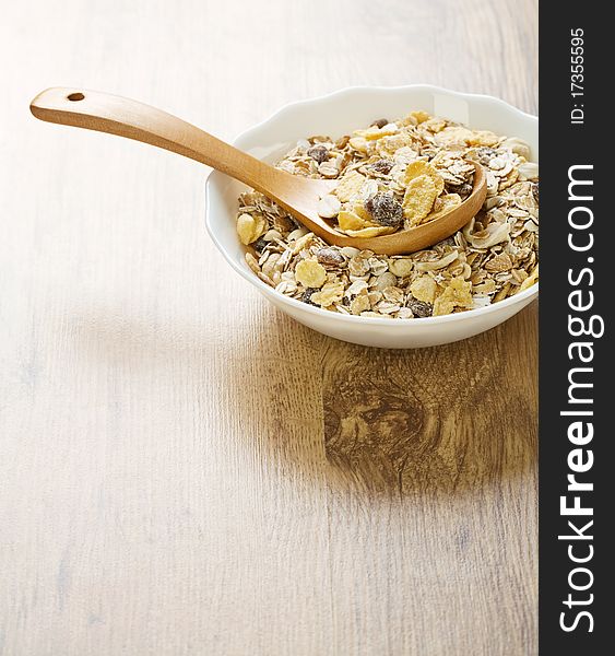 White ceramik bowl with muesli on wooden background