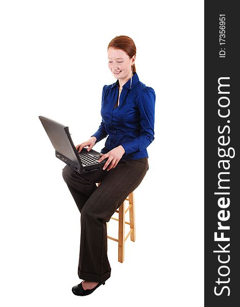 A business woman in a blue blouse and brown pants with a laptop on 
her lap with her long red hair in the studio, for white background. A business woman in a blue blouse and brown pants with a laptop on 
her lap with her long red hair in the studio, for white background.