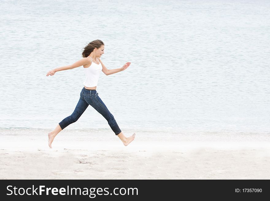 Young woman running on sand beach