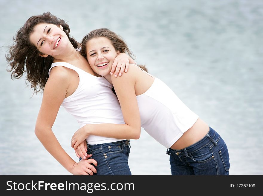 Two young happy women on sea background