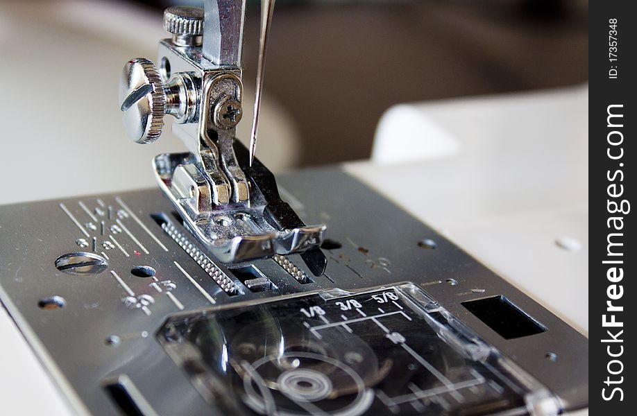 Close up view of the foot mechanism on a sewing machine. Close up view of the foot mechanism on a sewing machine.
