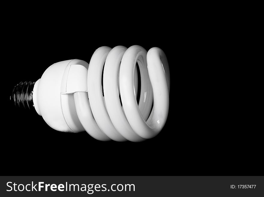 Close up of a compact fluorescent light bulb against a black background