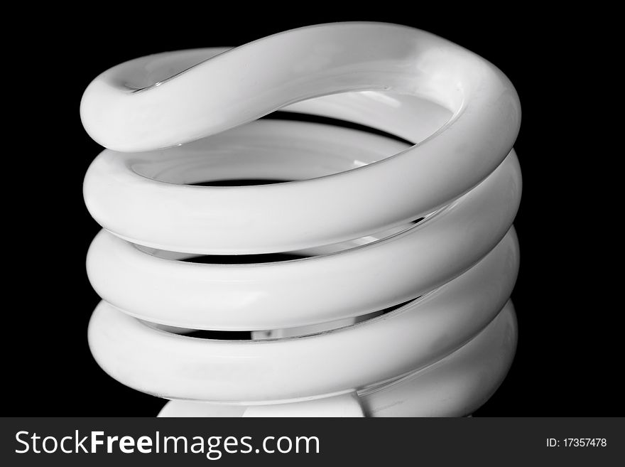 Close up of a compact fluorescent light bulb against a black background