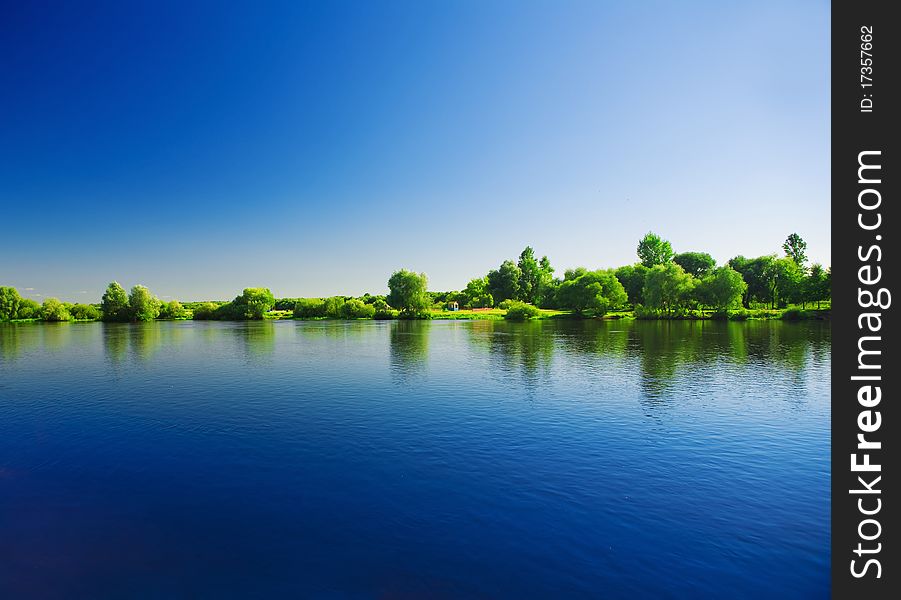 Horizontal image
viw on water of river
and green bush and trees
and contrast blue sky
with reflection of all it. Horizontal image
viw on water of river
and green bush and trees
and contrast blue sky
with reflection of all it