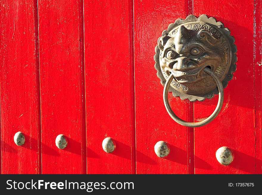 Brass Lion Head Door Handle On A Red Door