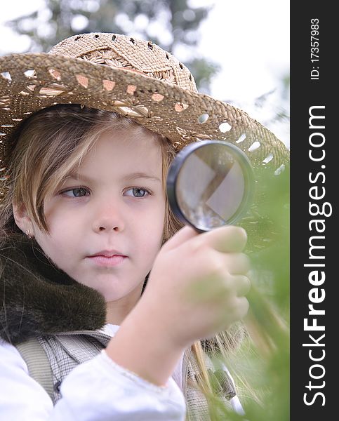 Girl with magnifying glass explores the nature