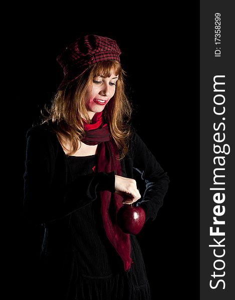 Girl with red socks hat scarf and apple on black background