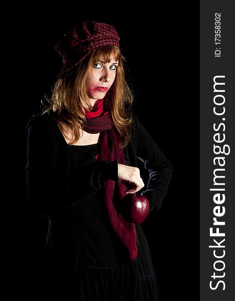 Girl with red socks hat scarf and apple on black background