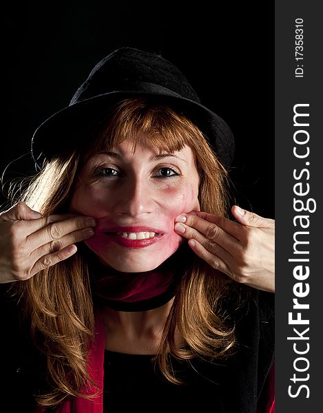 Girl with hat and lipstick deformed her face on black background