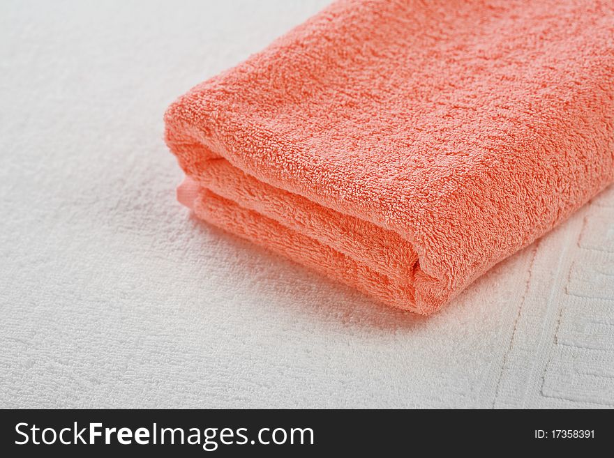 One pink cotton towel on white coton towel. One pink cotton towel on white coton towel