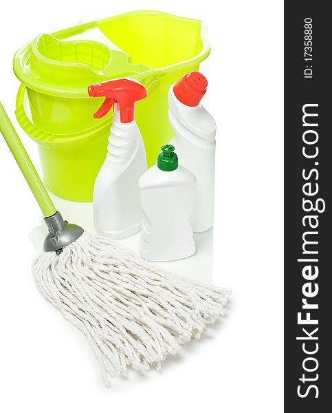 Plastical green bucket with mop and kitchen cleaners with olored lids and spray isolated on white background with reflection on white blurry background. Plastical green bucket with mop and kitchen cleaners with olored lids and spray isolated on white background with reflection on white blurry background