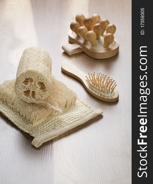 Bath sponge hairbrush and massager on wooden background