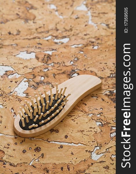 One wooden brown hairbrush on the background of the cork wood. One wooden brown hairbrush on the background of the cork wood