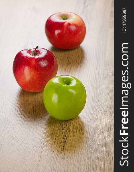 Three apples
red and green
wooden background