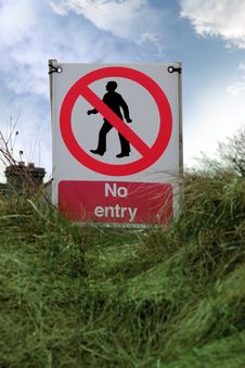 No Entry Sign On Grass With Clouds Stock Images