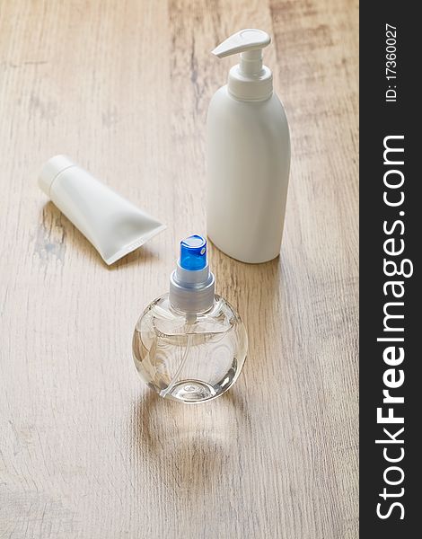 Tube and bottles for care on wooden background