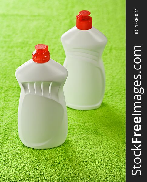 Two plastic bottles on green cotton towel. Two plastic bottles on green cotton towel
