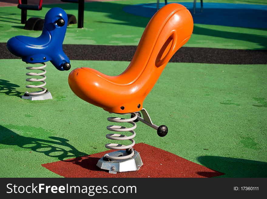 Empty blue and orange seesaws on a playground