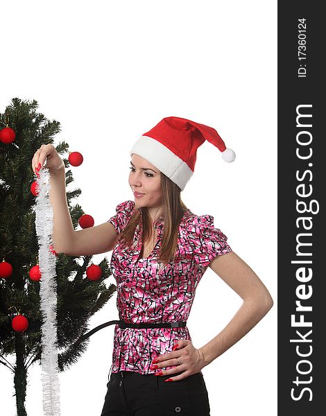 Woman in a christmas hat decorate a christmas tree. Woman in a christmas hat decorate a christmas tree