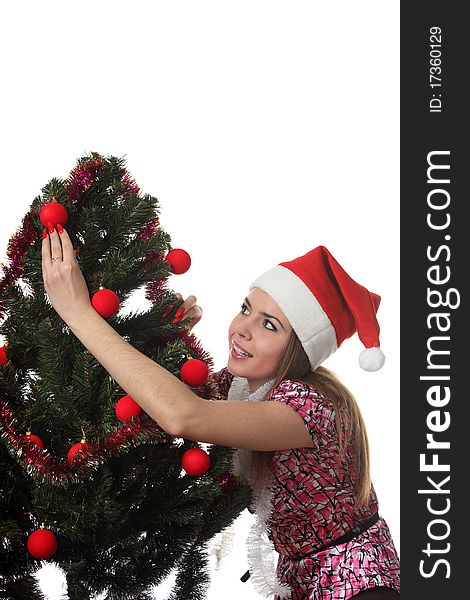 Woman in a christmas hat decorate a christmas tree. Woman in a christmas hat decorate a christmas tree