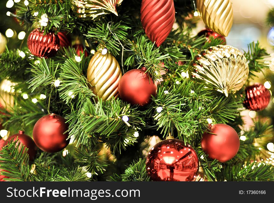 Red Christmas decorations and lights on a green tree