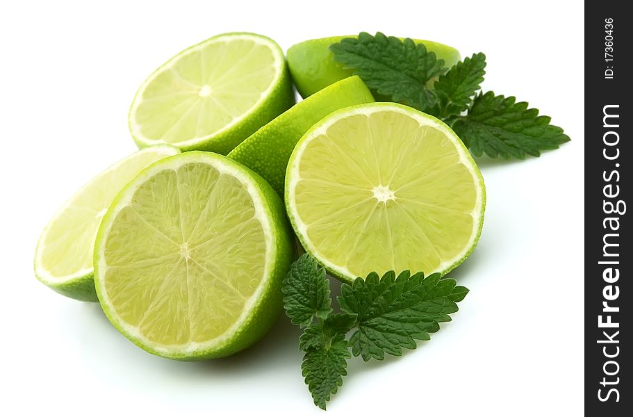 Lobes of a lime with a mint branch on a white background. Lobes of a lime with a mint branch on a white background