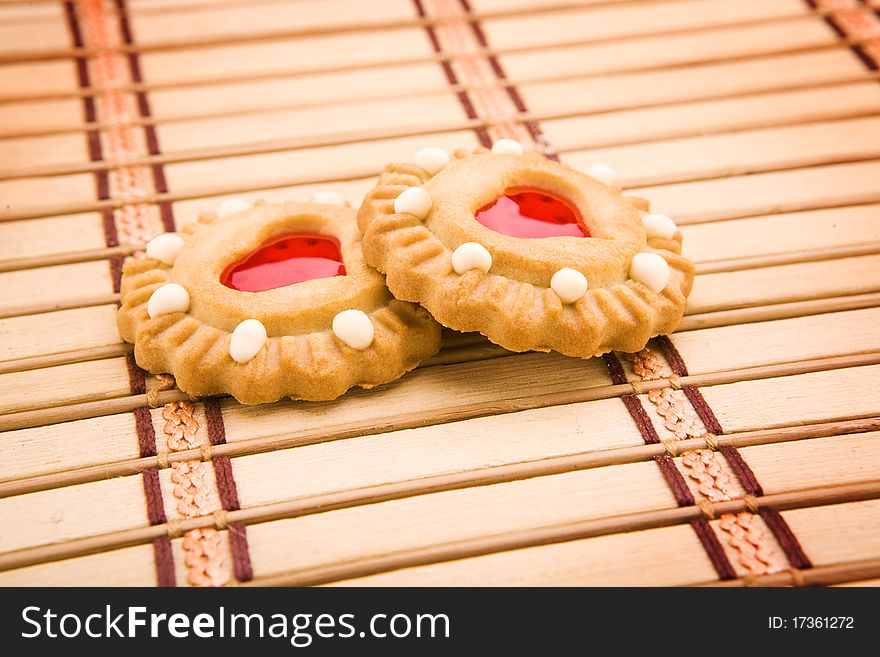 Two cooke with red liquor in the form of the heart on a mat. Two cooke with red liquor in the form of the heart on a mat