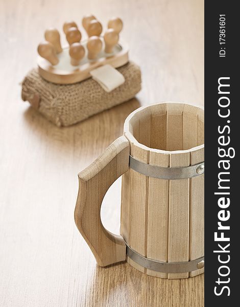 Bath sponge massager and wooden mug on wooden bakground