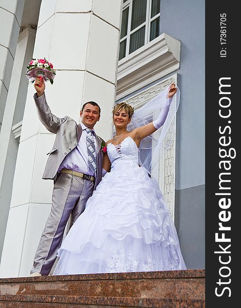 Bride and the groom on a background of a gray building