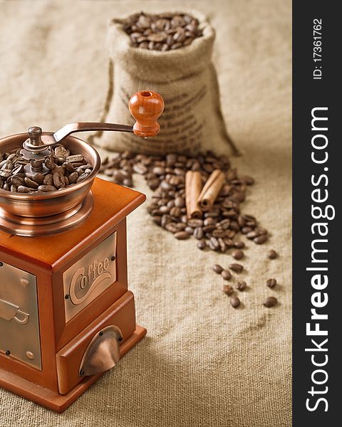 Coffee grains in bag cinnamon and coffee mill. Coffee grains in bag cinnamon and coffee mill
