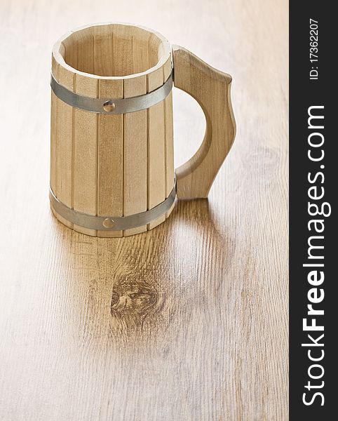 One brown baths wooden mug on a brown wooden background. One brown baths wooden mug on a brown wooden background