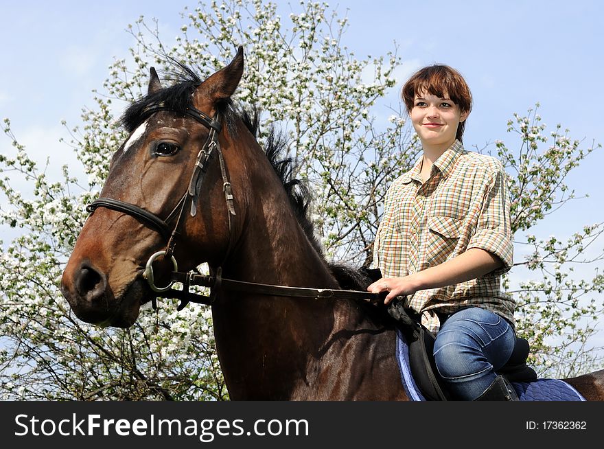 Young cowgirl and young horse in the  garden. Young cowgirl and young horse in the  garden