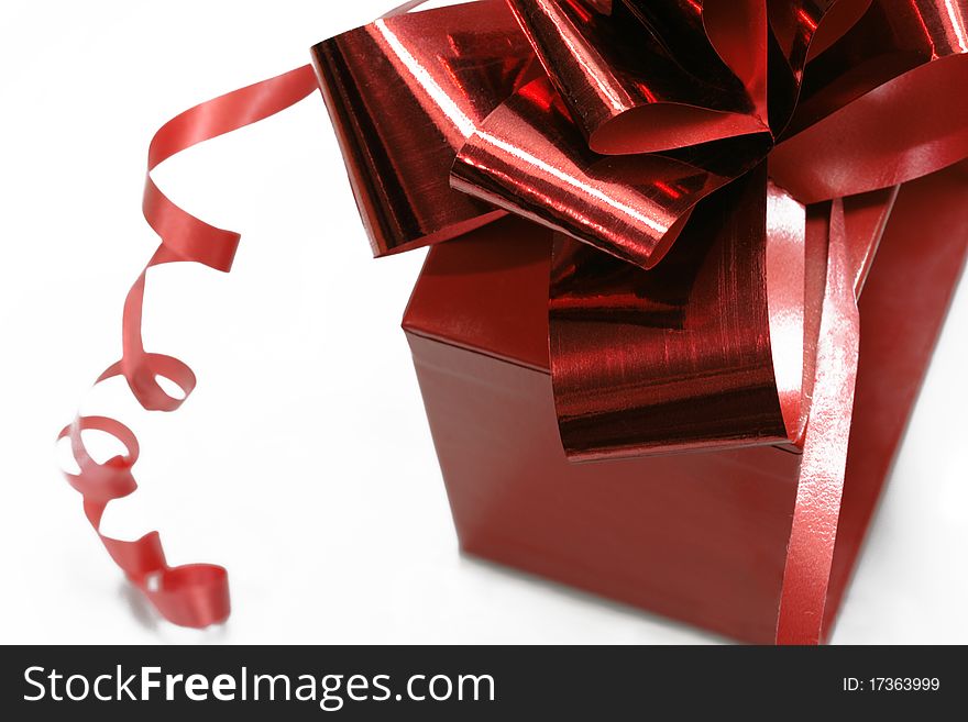 Red box wrapped in red gift ribbon in close up frame, isolated on white background. Red box wrapped in red gift ribbon in close up frame, isolated on white background