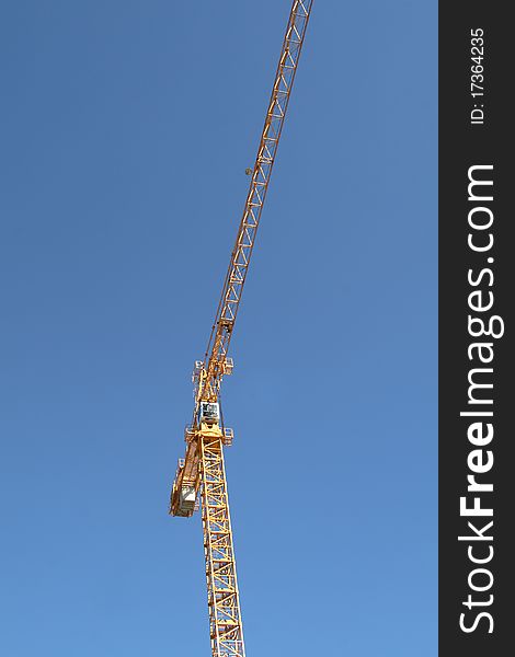 High-rise construction crane against blue sky